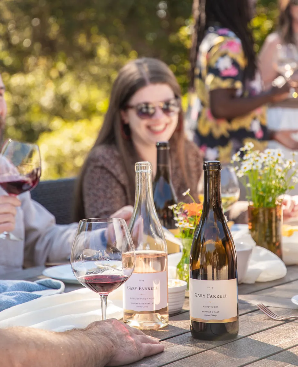 People eating and drinking wine at outdoor event