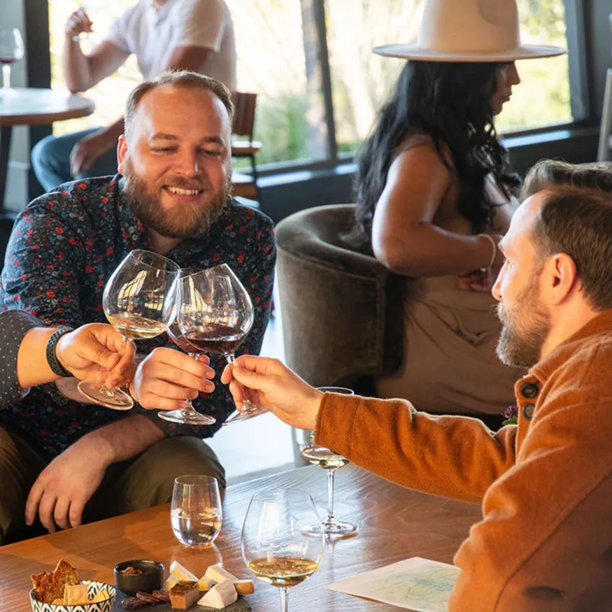Three men toasting with glasses of wine in the Gary Farrell tasting room