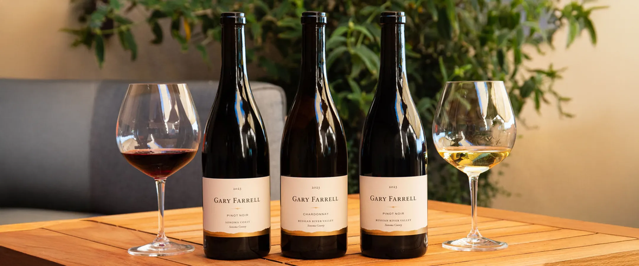 Three bottles of Gary Farrell wines on a wooden table