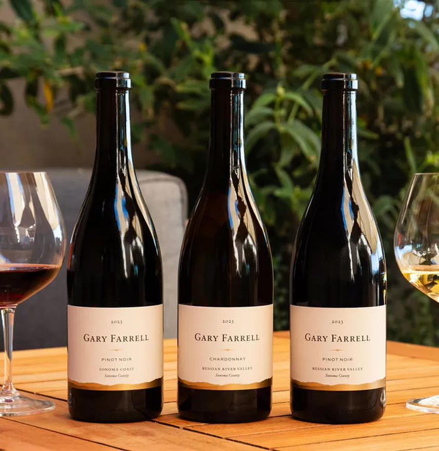 Three bottles of Gary Farrell wines on a wooden table
